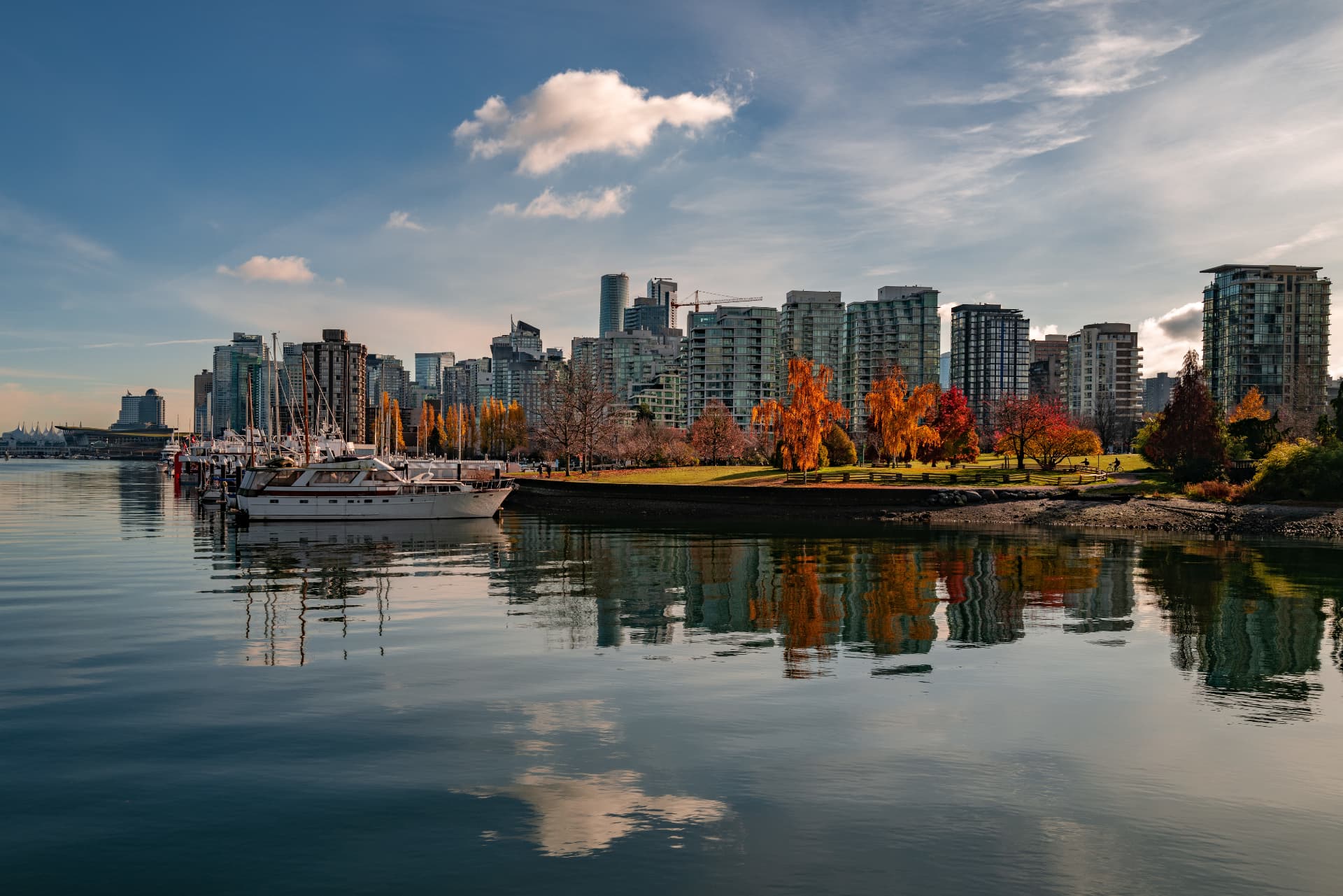 Vancouver skyline reflected in the bay at sunset, with snow-capped mountains in the background